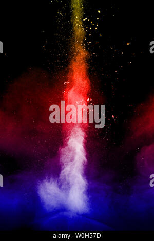 Multi colore Esplosione particelle su sfondo nero. La polvere colorata splatter su sfondo scuro. Foto Stock