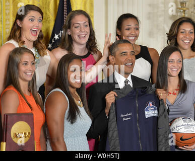 UConn donna giocatore di basket Stefanie Dolson (2a,L) scherzosamente mette "orecchie di coniglietto' dietro il Presidente Usa Barack Obama durante l opportunità di una foto come egli saluta il 2013 NCAA Champions alla Casa Bianca, 31 luglio 2013, a Washington, DC. Obama ha continuato una tradizione di accoglienza di Sports Champions per la Casa Bianca e li ringrazio per il loro servizio alla comunità. UPI/Mike Theiler Foto Stock