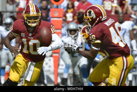 Washington Redskins quarterback Robert Griffin III (L) passi la palla al running back Alfred Morris nel durante il primo trimestre contro la Detroit Lions al campo di FedEx, Landover Maryland, Settembre 22, 2013. I Lions hanno vinto, 27-20 e le pellerosse cadde a 0-3 per aprire la stagione. UPI/Mike Theiler Foto Stock