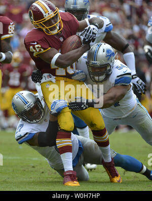 Washington Redskins running back Alfred Morris è affrontato da Detroit Lions difensori DeAndre Levy (R) e Glover Quin di FedEx Campo, Landover Maryland, Settembre 22, 2013. I Lions hanno vinto, 27-20 e le pellerosse cadde a 0-3 per aprire la stagione. UPI/Mike Theiler Foto Stock