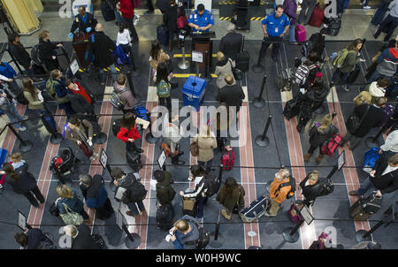 I viaggiatori di attendere in linea ad un TSA checkpoint di sicurezza all'Aeroporto Nazionale Ronald Reagan, Novembre 26, 2013, in Arlington, Virginia. Le difficili condizioni atmosferiche, che dovrebbe interessare la maggior parte del paese nei prossimi due giorni, ha il potenziale di causare enormi ritardi per viaggiatori in vacanza. UPI/Kevin Dietsch Foto Stock