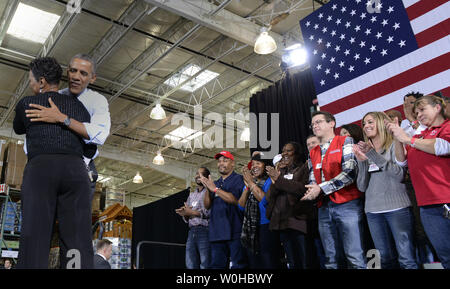 Il Presidente Usa Barack Obama abbracci Costco Assistant General Manager Teressa Allen come egli arriva a consegnare commento presso un negozio di rally, come egli prende il suo stato dell unione indirizzo su una escursione di due giorni al di fuori di Washington, in Lanham, Maryland, 29 gennaio 2014. Obama sta spingendo il Congresso a sollevare la Federal salario minimo come parte del suo piano economico. UPI/Mike Theiler Foto Stock