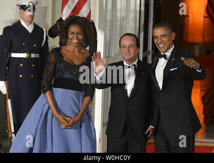 Il Presidente Usa Barack Obama (R) e il Presidente francese Francois Hollande onda per la stampa come essi sono uniti dalla First Lady Michelle Obama a dargli il benvenuto per una cena di Stato alla Casa Bianca, 11 febbraio 2014, a Washington, DC. Hollande è in visita di Stato a rafforzare bilaterale, commerciali, economiche e di sicurezza dei legami. UPI/Mike Theiler Foto Stock