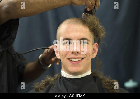 Arrivo Plebe Thomas Savage del nocciolo, Texas, ha la sua testa rasata sul giorno di induzione all'U.S. Naval Academy in Annapolis, Maryland, Luglio 1, 2014. Giorno di induzione è il primo giorno di istruzione per la classe di 2018 e imposta il fondamento della loro formazione militare. UPI/Kevin Dietsch Foto Stock