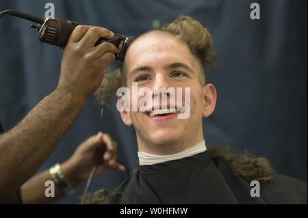 Arrivo Plebe Thomas Savage del nocciolo, Texas, ha la sua testa rasata sul giorno di induzione all'U.S. Naval Academy in Annapolis, Maryland, Luglio 1, 2014. Giorno di induzione è il primo giorno di istruzione per la classe di 2018 e imposta il fondamento della loro formazione militare. UPI/Kevin Dietsch Foto Stock