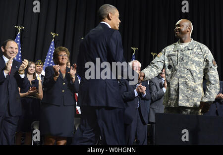 Stati Uniti Il presidente Barack Obama (C) scuote le mani con US Army Sgt. Principali McGruder James, come Veterans Affairs Segretario Robert McDonald (L) applaude prima di Obama firma HR 3230, veterani' accesso alle cure attraverso la scelta, la responsabilità e la trasparenza atto di 2014, 7 agosto 2014, a Fort Belvoir, Virginia. Il disegno di legge mira a coadiuvare il veterano militare salute cura semplificando la va la burocrazia in aree quali gli appuntamenti e la formazione del personale e il personale medico va in strutture di assistenza. UPI/Mike Theiler Foto Stock