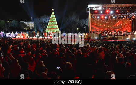 La Nazionale di albero di Natale è in piena illuminazione con la Casa Bianca in background come animatori sul palco concludere il National albero di Natale cerimonia di illuminazione, 4 dicembre 2014, a Washington, DC. La tradizione è stata iniziata nel 1923 dal Presidente Calvin Coolidge e storicamente inizia la stagione delle feste vacanze nella capitale degli Stati Uniti. UPI/Mike Theiler Foto Stock