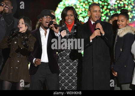 Stati Uniti Il presidente Barack Obama (2a,R), la First Lady Michelle Obama e la figlia Sasha (R) si uniscono in cantando con NE-YO, membri della quinta armonia (L) e gli altri durante la conclusione della nazionale di albero di Natale cerimonia di illuminazione, 4 dicembre 2014, a Washington, DC. La tradizione risale al 1923 e Presidente Calvin Coolidge e storicamente inizia la festosa stagione di vacanze nella capitale degli Stati Uniti. UPI/Mike Theiler Foto Stock