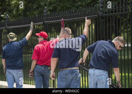 Lavoratori installare ulteriori picchi alla Casa Bianca recinto nel tentativo di scoraggiare i ponticelli di recinzione, a Washington D.C., il 1 luglio 2015. I picchi sono parte delle misure temporanee per terminare il recente aumento nel recinto dei ponticelli e altri intrusi alla Casa Bianca. Kevin Dietsch/UPI Foto Stock