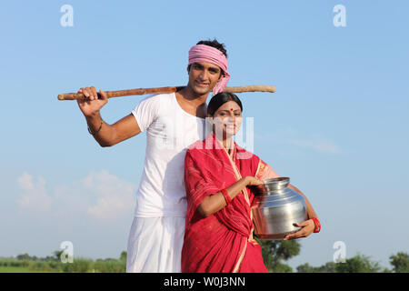 Indian contadino con sua moglie in piedi in un campo Foto Stock