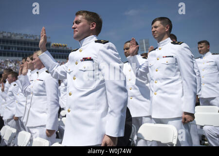 Laurea aspiranti guardiamarina prestare giuramento di ufficio durante il 2016 graduazione e cerimonia di messa in servizio presso l'U.S. Naval Academy in Annapolis, Maryland il 27 maggio 2016. La classe di laurea consiste di 1.076 uomini e donne che sarà commissionato come stemmi della marina o il 2o luogotenenti NEGLI STATI UNITI Marine Corps. Foto di Kevin Dietsch/UPI Foto Stock