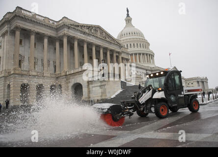 Un lavoratore cancella la neve DA PARTE DEGLI STATI UNITI Capitol Building dopo una notte di tempesta oggetto di dumping 2-4 pollici di ghiaccio e neve sulla capitale della nazione, a Washington D.C. il 14 marzo 2017. Un enorme tempesta di neve che ha colpito il nord-est lasciando più di un piede di neve in alcuni luoghi. Foto di Kevin Dietsch/UPI Foto Stock