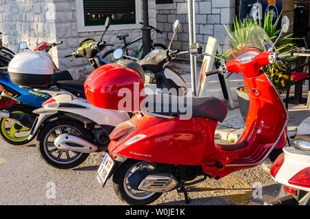 Scooter su un parcheggio in una giornata di sole, nella città di Trogir, Croazia. Foto Stock