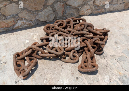 Chania, Creta, Grecia, Giugno 2019. Spedire la catena di ancoraggio con close up della ruggine links sulla banchina. Foto Stock