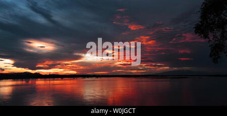 Colori pastello del tramonto si riflettono nelle acque del fiume Rufiji nella Riserva Selous, la più grande area faunistica in Africa Foto Stock