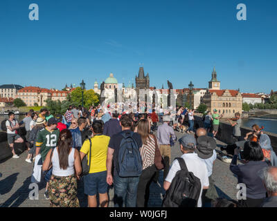 Praga, Repubblica Ceca - 8 Giugno 2019: masse turistiche e la folla sul Ponte Carlo sul fiume Moldava in un caldo giorno d'estate. Un concetto per il turismo di massa. Foto Stock