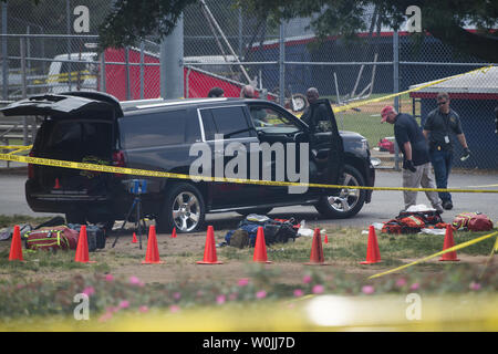 Gli investigatori di guardare le prove nei pressi di Simpson campo dove un pistolero aprì il fuoco durante un GOP pratica di baseball, in Alexandria, Virginia, 14 giugno 2017. Casa maggioranza frusta Steve Scalise e almeno tre altri sono stati girati durante la pratica, polizia e testimoni ha detto. Foto di Molly Riley/UPI Foto Stock