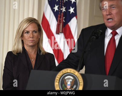 Kirstjen Nielsen (L), annunciato come il candidato come il nuovo Department of Homeland Security segretario, ascolta commento dal presidente Donald Trump, nella Sala Est della Casa Bianca, 12 ottobre 2017, a Washington, DC. Nielsen, un esperto di sicurezza informatica, erano state servendo come vice capo del personale della Casa Bianca. Foto di Mike Theiler/UPI Foto Stock