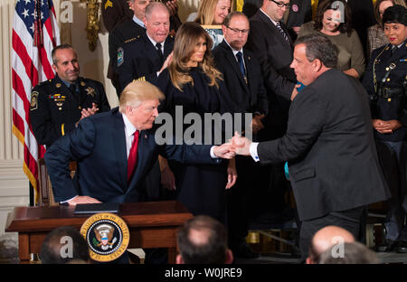 Presidente Donald Trump dà una penna per New Jersey governatore Chris Christie dopo la firma di un memorandum presidenziale che dichiara la crisi oppioidi un'emergenza sanitaria pubblica, nella Sala Est della Casa Bianca a Washington D.C. il 26 ottobre 2017. Trump era unita da persone effettuata dall'epidemia e primi responder e membri delle forze dell'ordine. Foto di Kevin Dietsch/UPI Foto Stock