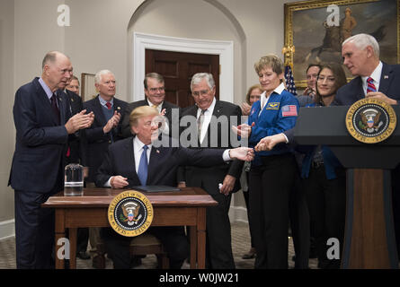 Presidente Donald Trump dà una penna al Vice Presidente Mike Pence segni la politica spaziale direttiva 1, nella sala Roosevelt alla Casa Bianca il 11 dicembre 2017 a Washington D.C. La direttiva assegna la NASA per avviare uno spazio per tornare astronauti americani torna alla Luna e su Marte. Trump era unita da parte dei membri del Consiglio sullo spazio, astronauti e membri del Congresso. Foto di Kevin Dietsch/UPI Foto Stock