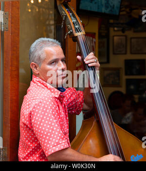 L'uomo gioca contrabbasso sul lato della strada in un aperto facciate ristorante adiacente a Plaza Vieja, Avana, (Havana Vieja), Cuba, Caraibi Foto Stock