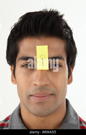 Uomo con un adesivo nota sulla sua fronte Foto Stock