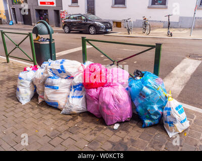 Bianco, blu e rosa sacchi per i rifiuti in attesa di raccolta - Bruxelles, Belgio. Foto Stock