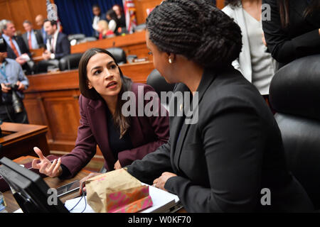 Congressista Alessandria Ocasio-Cortez parla di U.S. Rappresentante Ayanna Pressley quando avvocato Michael D. Cohen testimonia davanti la casa comitato di sorveglianza il 27 febbraio 2019 a Washington DC. Cohen, che una volta era uno dei Presidente Trump's più fidati aiutanti e avvocati, ha preso il testimone di stand per la sua prima e unica apparizione pubblica prima del Congresso di mercoledì per discutere il presidente di carattere personale e possibile condotta criminale. Foto di Kevin Dietsch/UPI Foto Stock