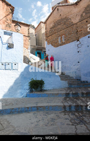 Chefchaouen, Marocco - 3 Maggio 2019: Le donne con abbigliamento marocchino in un tradizionale strade di Chaouen, una città molto turistica del nord del Marocco Foto Stock