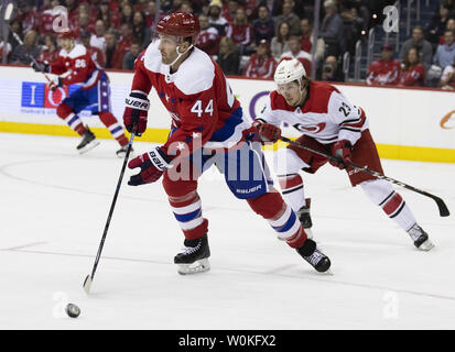 Washington capitelli defenceman Brooks Orpik (44) porta il puck mentre difeso da Carolina Hurricanes ala sinistra Brock McGinn (23) durante il secondo periodo in capitale una arena a Washington D.C. il 26 marzo 2019. I capitelli portano la divisione metropolitana ed è in grado di conquistare una tazza di Stanley posizione Playoff stasera. Gli uragani rimangono in una wild card posizione come essi inseguire un posto per i playoff. Foto di Alex Edelman/UPI Foto Stock