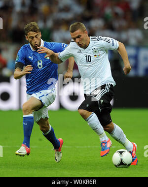 Lukas Podolski della Germania è inseguito da Claudio Marchisio dell Italia durante l'Euro 2012 Semi-Final match presso lo Stadio Nazionale di Varsavia, Polonia, il 28 giugno 2012. UPI/Chris Brunskill Foto Stock