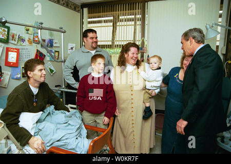 Il Presidente George W Bush abbraccia la madre-in-legge degli Stati Uniti Il personale dell'esercito sergente Roy Mitchell, a sinistra, come gli altri membri della famiglia guardare durante la visita del Presidente a Walter Reed Army Medical Center di Washinton, D.C., giovedì 18 dicembre, 2003. Il presidente Bush ha appena presentato Sgt. Mitchell il cuore viola per ferite subite mentre in servizio in Iraq. Sgt. Mitchell è da Milano, Indiana. Altri membri della famiglia sono, da sinistra, Jerry, Stoneking Zachiary Bice e Michelle Mitchell, che tiene il Mitchell's figlio Jerrett. (UPI foto/Eric Draper/Casa bianca) Foto Stock