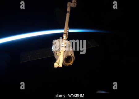 Con il buio, terra del trend con orizzonte di riferimento e la linea sottile di atmosfera formando una cornice, la SpaceX Dragon commerciale cargo craft è agganciato dal Canadarm2 braccio robotico alla Stazione Spaziale Internazionale il 25 maggio 2012. Dragon è diventato il primo commercialmente sviluppato un veicolo spaziale ad essere lanciato alla stazione di unirsi a russi, europei e giapponesi artigianali di riordino del servizio che il complesso durante il ripristino di una capacità degli Stati Uniti per consegnare cargo per il laboratorio orbitale. Dragon tornato sulla Terra il 31 maggio per il recupero. UPI/NASA Foto Stock