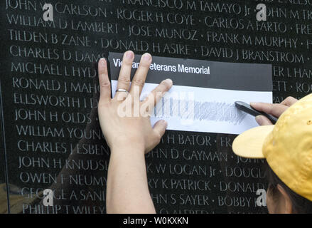 Un volontario che aiuta un visitatore etch il nome di una persona cara come migliaia di persone che pagano i loro aspetti presso il Memoriale dei Veterani del Vietnam sul National Mall durante il weekend del Memorial Day in Washington, DC, Sabato 27 Maggio, 2017. Più di 58.000 nomi di militari che hanno perso la vita durante la Guerra del Vietnam sono elencati sul memorial wall. Foto di Pat Benic/UPI Foto Stock