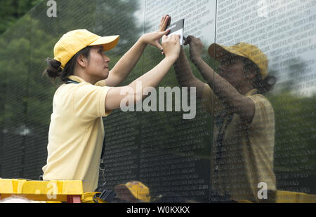 Un volontario che aiuta un visitatore etch il nome di una persona cara come migliaia di persone che pagano i loro aspetti presso il Memoriale dei Veterani del Vietnam sul National Mall durante il weekend del Memorial Day in Washington, DC, Sabato 27 Maggio, 2017. Più di 58.000 nomi di militari che hanno perso la vita durante la Guerra del Vietnam sono elencati sul memorial wall. Foto di Pat Benic/UPI Foto Stock