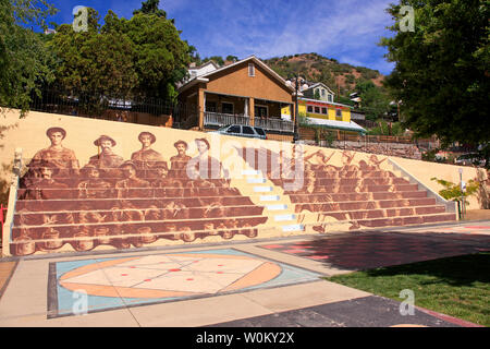 Dipinto murale di minatori e soldati dai tempi passati sui posti a sedere presso il parco della città Anfiteatro al Bisbee AZ Foto Stock