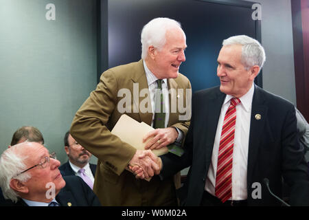 Della maggioranza del senato frusta John Cornyn (R-TX) scuote le mani con sost. Lloyd Doggett (D-TX) come Sen. Bernie Sanders (I-VT) guarda (sinistra) prima di una riunione della Camera e del Senato i conferenzieri dopo i leader del GOP ha annunciato che erano venuti a un accordo su una riforma fiscale bill al Campidoglio di Washington il 13 dicembre 2017. I democratici hanno chiesto di procedere a una votazione della legge essere ritardata fino a quando AlabamaÕs Senatore eletto Doug Jones può essere seduto. Foto di Erin Schaff/UPI Foto Stock