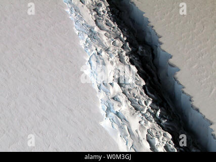 Vista della Rift attraverso la Larsen C Ripiano di ghiaccio come visto dal punto di osservazione della NASA DC-8 aerei di ricerca il 10 novembre 2016. Lo scienziato della NASA John Sonntag scattato le foto del 10 novembre 2016, durante un'operazione IceBridge volo. La Rift in Larsen C misura circa 100 metri (300 piedi) di larghezza e tagli di circa mezzo chilometro (un terzo di miglio) profondo, completamente attraverso la parte inferiore della mensola di ghiaccio. Mentre la frattura è lungo e crescente più a lungo, non raggiungono ancora attraverso l'intero ripiano. Quando ciò accade, Larsen C sarà versato un iceberg circa le dimensioni del Delaware. A volte tra Ju Foto Stock