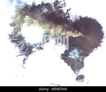 Shiveluch, uno dei vulcani più attivi al mondo, è visto inserimenti attraverso al di sopra di una solida piattaforma di cloud, con un pennacchio di cenere streaming per l'occidente. Situato sulla penisola di Kamchatka nella lontana Russia orientale, è uno dei molti vulcani attivi sulla penisola. Nelle vicinanze, a sud, il più piccolo vulcano Bezymianny può essere visto con un piccolo pennacchio di vapore proveniente dalla sua cima. L'immagine è stata acquisita il 20 agosto 2017, copre un area di 12 da 14 miglia (19,5 da 22,7 chilometri), e si trova a 56,1 gradi nord, 160,6 gradi a est. La NASA/UPI Foto Stock