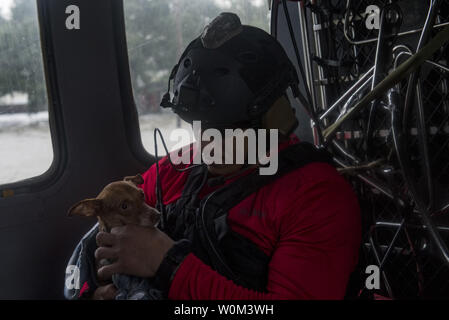 Un Pararescueman dalla 38th Rescue Squadron dries off a filamento di un cane che è stato salvato, il 30 agosto 2017, a Houston, in Texas area. La 347Gruppo di salvataggio da Moody Air Force Base, Ga. ha risposto con il suo salvataggio aereo e il personale a sostegno del FEMA dopo l uragano Harvey ha portato le inondazioni e la distruzione di parti del Texas. Foto di Tech. Sgt. Zachary Wolf/STATI UNITI Air Force/UPI Foto Stock