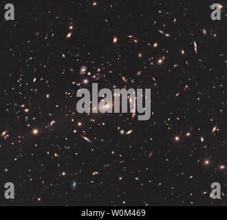 Questa immagine dalla NASA/ESA telescopio spaziale Hubble, rilasciato il 13 ottobre 2011, mostra il cluster Galaxy MAC J1206. Ammassi di galassie come questi hanno enorme massa e la loro gravità è abbastanza potente da visibilmente piegare il percorso della luce, un po' come una lente di ingrandimento. Questi raggruppamenti sono strumenti utili per studiare molto distanti oggetti perché questa lente-come comportamento amplifica la luce proveniente da galassie lontane in background. Si tratta di uno dei cluster 25 Essendo studiato come parte dello scontro (Cluster Lensing e Supernova survey con Hubble) programma, un importante progetto per la costruzione di una libreria di scientif Foto Stock