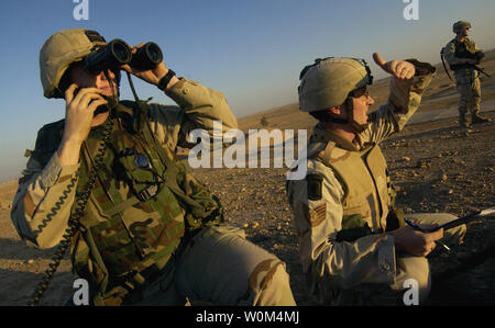 Stati Uniti Esercito capitano David Spencer e Sgt tecnico. Ryan Knight, Tactical Air parte di controllo, 4° aria Gruppo di supporto, occhio un bersaglio strategico all'orizzonte di Kirkuk, Iraq, come parte del funzionamento Ivy Cyclone, di un insieme di bracci-operazione destinata alla radice e schiacciare gli insorti in Iraq di recente. Rilascio delle immagini Novembre 24, 2003. (UPI foto/Jeffrey A. Wolfe/Air Force) Foto Stock