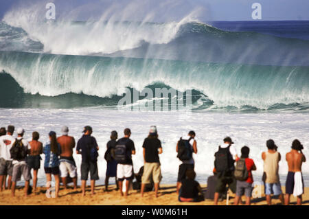 Spettatori assistono onde massiccia crash presso la sede per il Rip Curl Pro Pipeline Masters al Banzai Pipeline sulla North Shore di Oahu, Hawaii su dicembre 13, 2004. Il concorso è stato messo in attesa a causa di tempesta condizioni di surf che ha scosso la North Shore. Il Rip Curl Pipeline Masters è l'evento finale per gli uomini sul 2004 favorisce il Campionato mondiale ASP Tour e caratteristiche la top 45 surfers e tre wild card concorrenti. (UPI foto/Pierre Tostee/ASP Tostee) Foto Stock