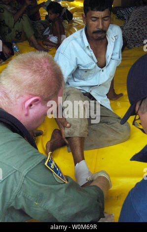 Hospital Corpsman 3rd Class House di Newton, Kansas, cambia una benda per una vittima del recente tsunami Al Sultan Iskandar Muda Air Force Base a Banda Aceh e Sumatra, Indonesia, il 9 gennaio, 2005. Le équipe mediche da Abramo Lincoln Carrier Strike gruppo, CVW-2 e l'Organizzazione internazionale per la migrazione (IOM) impostare fino ad un sito di triage situato sulla Sultan Iskandar Muda Air Force Base, a Banda Aceh e Sumatra. (UPI foto/US Navy/Renee F. Martinez) Foto Stock