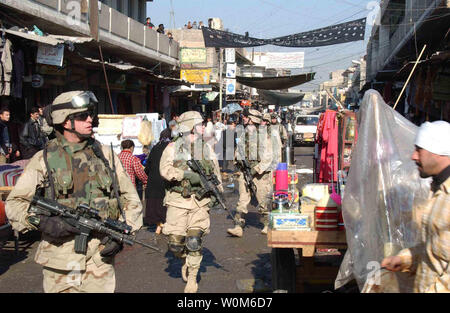 Stati Uniti I soldati dell esercito a piedi attraverso un mercato in Al quartiere Sudeek durante una pattuglia smontati a Mosul, Iraq, il 9 gennaio, 2005. I soldati sono assegnati al Bravo Company, 2° Battaglione, 325Parachute Reggimento di Fanteria, attaccato alla Task Force di Tacoma. (UPI Photo/ Adam Sanders/Esercito) Foto Stock