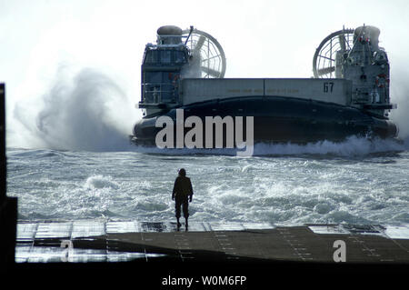 Boatswain compagno del 3° di classe Tony Layton orologi come una Landing Craft Air Cushion (LCAC), assegnato a Assault Craft quattro unità, si prepara ad entrare nel pozzetto ponte dell'assalto anfibio nave USS Bataan (LHD 5) il 25 gennaio 2005 nell'Oceano Atlantico. Il Bataan sta completando il suo certificazioni finale per garantire che la nave è pronto per la distribuzione. (UPI foto/Jeremy L. Grisham/Marina) Foto Stock