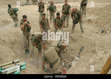 Stati Uniti Marines rimuovere uno dei diversi casi di inesplosi trovati in una cache di armi sepolto fuori del kharma, Iraq, il 3 marzo 2005. I marines sono dal 2 ingegnere di combattimento battaglione, fissata per il 3 ° Battaglione, 8° Reggimento Marine, e sono impegnate in sicurezza e le operazioni di stabilizzazione nel Al Anbar Provincia, Iraq. (UPI foto/Trevor R. dono/Marines) Foto Stock