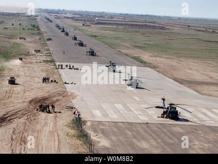 Stati Uniti I soldati dell esercito, soldati iracheni e aeromobili degli Stati Uniti sono posizionati sulla pista di atterraggio per aerei a inoltrare una base operativa Remagen, Iraq, in preparazione per il funzionamento Swarmer il 16 marzo 2006. Operazione Swarmer è un combinato di air assault operazione per cancellare la zona nord-est di Samarra di presunti insorti. I soldati sono dall'esercito iracheno di vigili del 1°, 4° Divisione, e gli Stati Uniti Dell'esercito 101st Divisione Aerotrasportata di terza Brigata Combat Team e la 101st combattere la Brigata Aerea. (UPI foto/Antony Joseph/STATI UNITI Esercito) Foto Stock