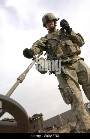 Army Spc. Joe Browning utilizza un rivelatore di metalli per cercare armi sepolta la cache e i materiali usati per la costruzione di ordigni esplosivi artigianali durante una pattuglia di vicinato a Mosul, Iraq, il 18 marzo 2006. (UPI foto/John M. Foster/USAF) Foto Stock