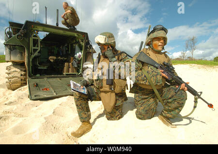 Stati Uniti Marine Corps Capt. Jon Curtis (sinistra) chiamate in un attacco aereo come Cpl. Eric Brookes fornisce la sicurezza come parte di una simulazione di Beach Assault on Kaneohe Bay Marine Corps base, Hawaii, luglio 18, 2006, durante l'esercizio, Rim del Pacifico 2006. L'esercizio, comunemente chiamato RIMPAC, riunisce forze militari provenienti da Australia, Canada, Cile, Perù, del Giappone, della Repubblica di Corea, il Regno Unito e gli Stati Uniti nel più grande del mondo biennale esercizio marittimo. Curtis e Brookes sono attaccati al Team di supporto con la società Eco, 1° Reggimento Marine. UPI foto/Marcos T. Hernandez/STATI UNITI Foto Stock